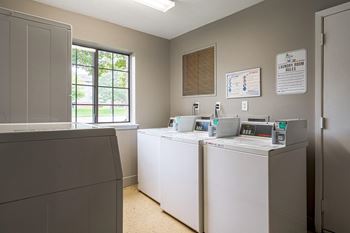 A laundry room with four washers and dryers